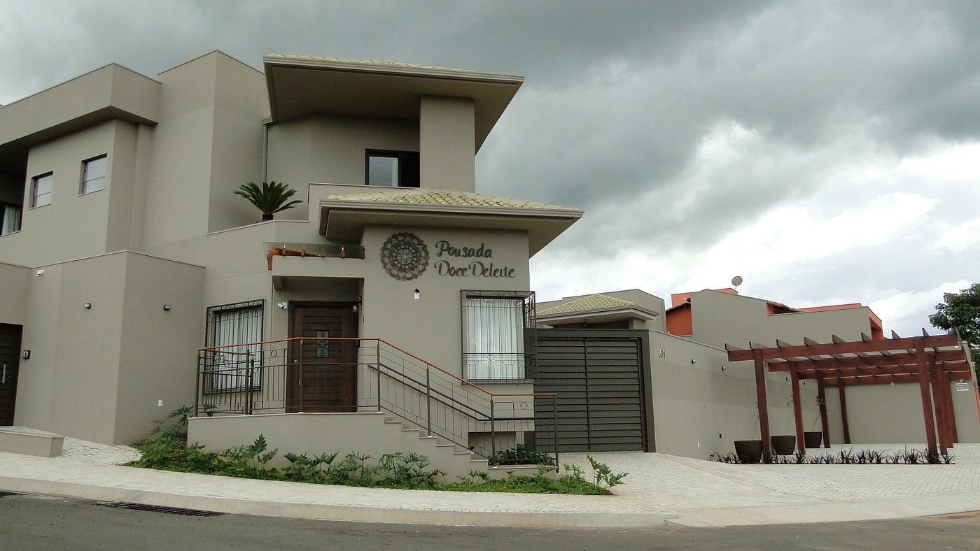 Fachada da pousada com a mandala e o nome na parede