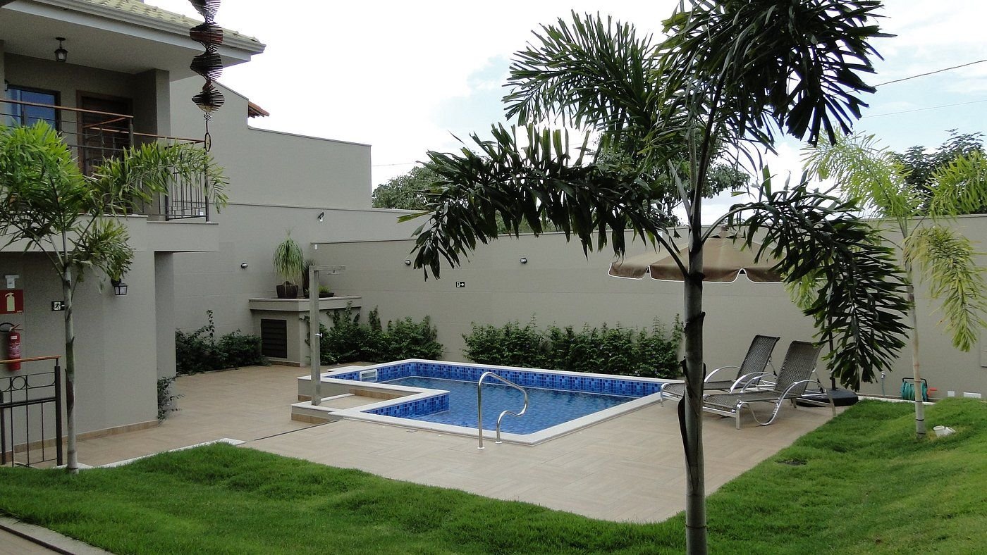 Piscina com palmeiras e gramado