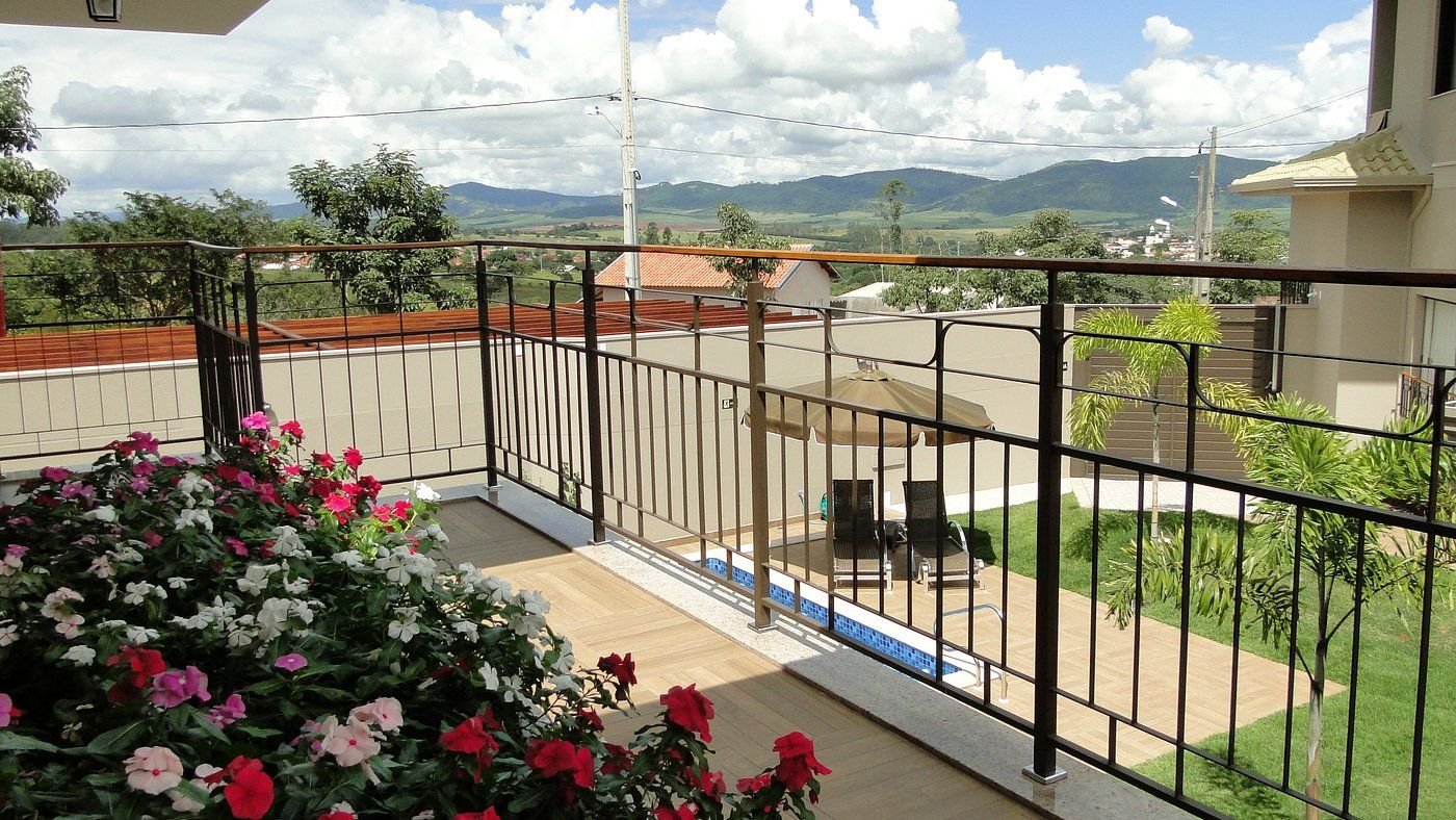 Passarela com floreira, piscina abaixo e serras ao fundo